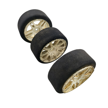 Team Associated Nitro TC3 foam tires on cream colored wheels x3, one different